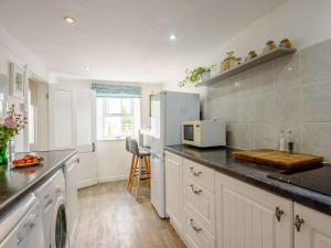 a kitchen with a white refrigerator and a counter at 2 Bed in Nefyn 44492 in Nefyn +18 photos