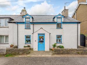 a white house with a blue door at 2 Bed in Nefyn 44492 in Nefyn