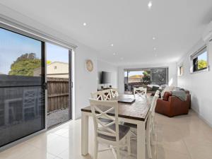 a dining room and living room with a table and chairs at Time Out on Flinders in Indented Head