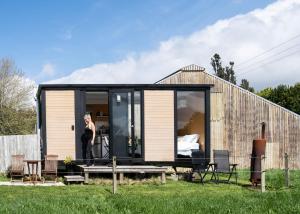 a woman standing outside of a tiny house at Forest Farm Tiny House by Tiny Away in Tauranga