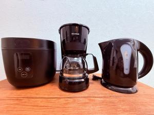 宇都宮市にあるStay Plus Sophiaの木製のテーブルの上に置かれた2つの黒い家電製品