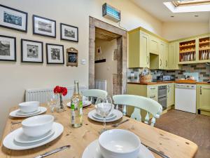 Una cocina con una mesa de madera con platos blancos encima. en 3 Bed in Bamburgh CN022, en Smeafield