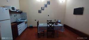 a kitchen with a table and chairs and a refrigerator at Alojamiento Temporal MartinaS in San Fernando del Valle de Catamarca