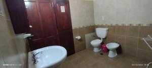 a bathroom with two toilets and a sink and a door at Alojamiento Temporal MartinaS in San Fernando del Valle de Catamarca