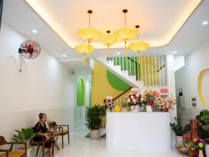 a woman sits in a waiting room at a hospital at Ami Hoi An Home in Hoi An
