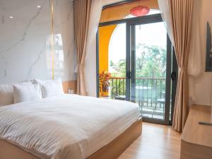 a bedroom with a large bed and a balcony at Ami Hoi An Home in Hoi An +103 photos