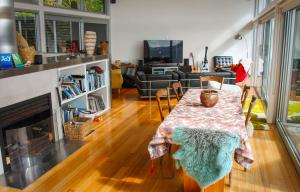 a living room with a table and a fireplace at Hosts on the Coast Paku Paradise in Tairua +19 photos