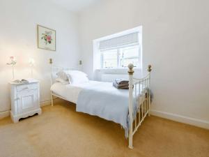 Un dormitorio blanco con una cama y una ventana. en 2 Bed in Bourton-on-the-Water 46677, en Bourton on the Water