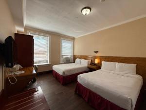 een hotelkamer met twee bedden en een flatscreen-tv bij The Baron Hotel in Washington
