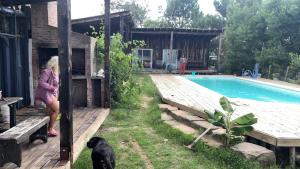 een vrouw die naast een hond staat bij een zwembad bij Cielo abierto in Maldonado