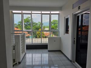 CibitungにあるTamastu JSHouse Syariah Sentul Cityの大きな窓とバルコニーが備わる空の部屋です。