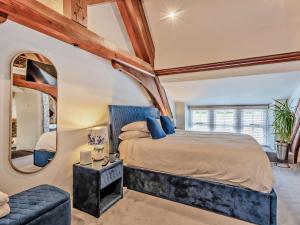 a bedroom with a large bed and a round mirror at 2 Bed in Hawkshead 93167 in Hawkshead