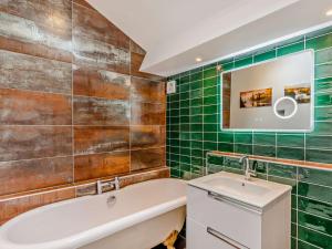 a bathroom with green tiles and a tub and a sink at 2 Bed in Hawkshead 93167 in Hawkshead +13 photos