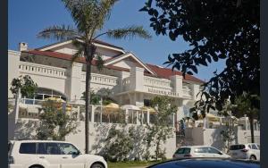 un bâtiment blanc avec des voitures garées devant dans l'établissement Freshwater Coastal Hideaway - 1 bedroom sleeps 4, à Sydney