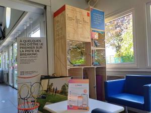 a room with a table and a sign on the wall at Hôtel Ibis Budget Nantes Ouest Atlantis Couëron in Couëron