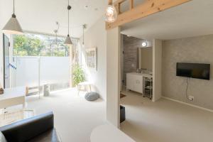 a living room with a couch and a tv at Flower Base Lily House - Vacation STAY 57830v in Fukuoka