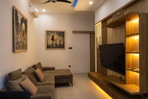 a living room with a couch and a flat screen tv at Villa D'Ling in Tianyar