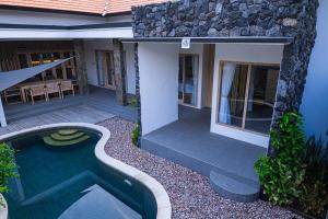 a house with a swimming pool in front of it at Villa D'Ling in Tianyar