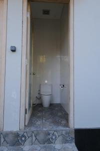 a bathroom with a toilet in a hallway at Villa D'Ling in Tianyar
