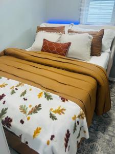 a bed with a blanket and pillows on it at Fancy Studio Private Entrance in Selden