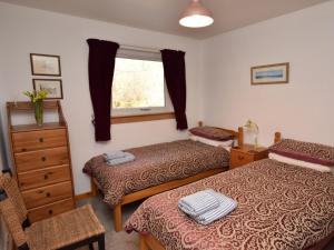 1 dormitorio con 2 camas, vestidor y ventana en 3 Bed in Drumnadrochit IN633, en Balnain