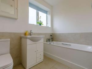 a bathroom with a tub and a toilet and a sink at 3 Bed in West Bay DC117 in West Bay +15 photos