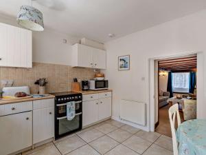 a kitchen with white cabinets and a stove top oven at 2 Bed in West Bay 77557 in Loders +8 photos