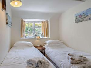 two beds in a room with a window at 2 Bed in West Bay 77557 in Loders