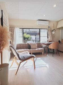 a living room with a couch and a chair at 伊勢神宮内宮前-民泊宿i s e s h i m a -205 in Ise