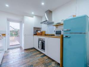a kitchen with a blue refrigerator and a wooden floor at 4 Bed in Gosforth 85807 in Gosforth