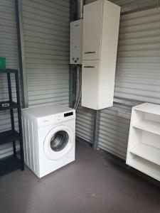 a washing machine is sitting next to a garage at Studio à Tamaon 