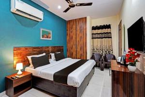 une chambre avec un lit et un mur bleu dans l'établissement Royal Hotel, à Gurgaon