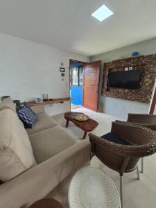 a living room with a couch and chairs and a tv at Villas do Rio 02 in Pôrto de Pedras +31 photos