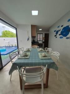 a dining room with a green table and chairs at Villas do Rio 02 in Pôrto de Pedras