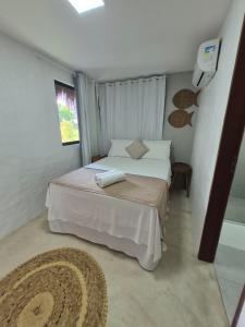 a small bedroom with a bed and a window at Villas do Rio 02 in Pôrto de Pedras