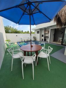 a table and chairs with an umbrella on a patio at Villas do Rio 02 in Pôrto de Pedras