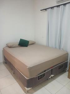 a bed sitting in a room with avertisementatronatronstrationstrationstration at Recanto Dona Antônia in Piçarras