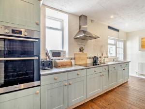 a kitchen with white cabinets and a stove top oven at 2 Bed in Outgate and Tarn Hows LLH01 in Hawkshead