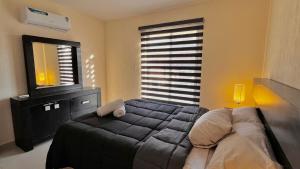 a bedroom with a bed and a dresser and a mirror at Altézza House in Tlajomulco de Zúñiga