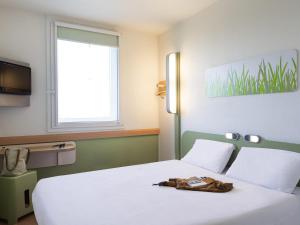 a bedroom with a white bed and a window at ibis budget Roissy CDG Paris Nord 2 in Roissy-en-France +48 photos