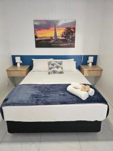 a bedroom with a large bed with two night stands at Villa La Sini Yeppoon in Yeppoon