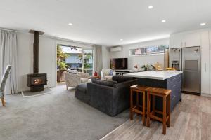 a kitchen and living room with a couch and a stove at Hannahs Bay Haven - Rotorua Holiday Home in Rotokawa
