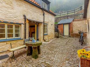 a stone courtyard with a table in front of a building at 4 Bed in Dunster 90504 in Dunster