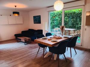 a dining room and living room with a table and chairs at Habitation Keira in Saint-Denis