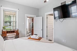 Un dormitorio blanco con una cama y un televisor de pantalla plana. en Maison Champignon, en St. Charles