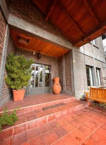 a front door of a house with a vase on the porch at Hosteria Andina in Esquel +7 photos