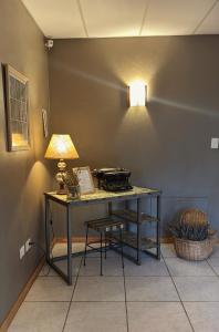 a desk with a lamp and a chair in a room at Hosteria Andina in Esquel