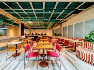 un restaurante con mesas, sillas y ventanas en ibis budget Sao Paulo Paulista, en São Paulo