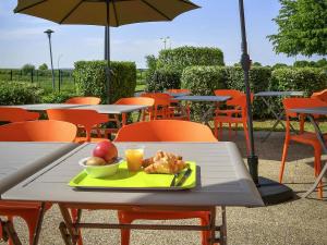a plate of food on a table with an umbrella at ibis budget Coutances in Coutances