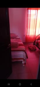 a bedroom with pink walls and a bed with red sheets at Villa Coral Gables Casa in Puerto Jiménez +5 photos